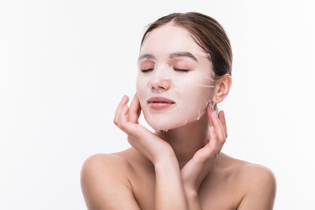 face-care-beauty-treatments-young-woman-with-cloth-moisturizing-mask-her-face-isolated-gray-wall_231208-1516