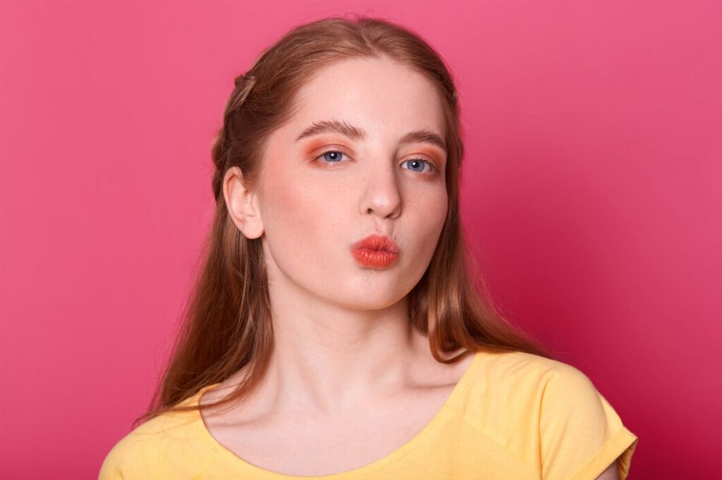 lovely female with long straight hair wears yellow t shirt rounds lips as going recieve kiss from boyfriend has mysterious facial expression isolated pink 176532 8738 lovely-female-with-long-straight-hair-wears-yellow-t-shirt-rounds-lips-as-going-recieve-kiss-from-boyfriend-has-mysterious-facial-expression-isolated-pink_176532-8738