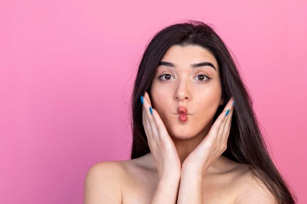 young beautiful lady winco her lips looking camera pink background high quality photo 144627 76476 young-beautiful-lady-winco-her-lips-looking-camera-pink-background-high-quality-photo_144627-76476